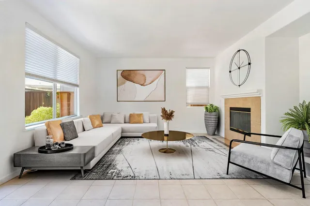 a living room with furniture a clock on wall and a fireplace