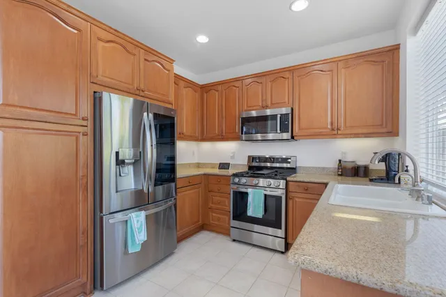 a kitchen with stainless steel appliances granite countertop a refrigerator stove and sink