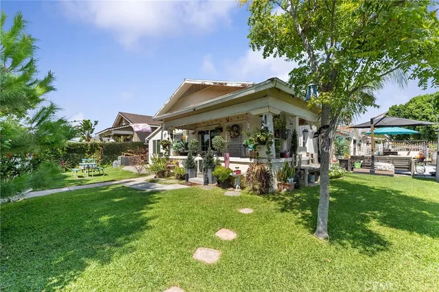 a view of a backyard with table and chairs and a large tree