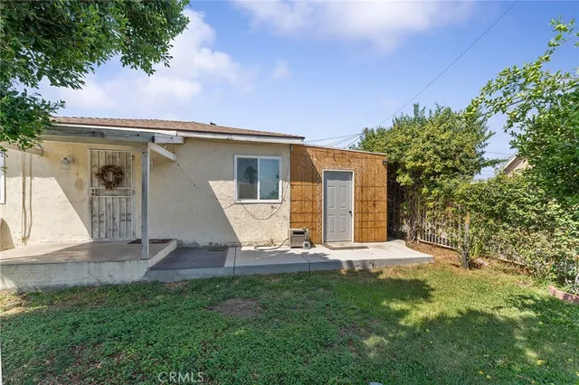 a view of a house with backyard and a tree