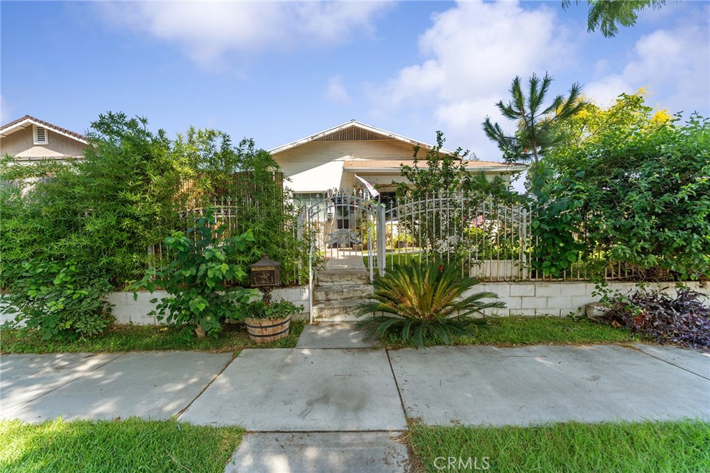 491 East C Street Colton, CA 92324 - Photo 6 of 58 a front view of a house with a yard and plant in front of it