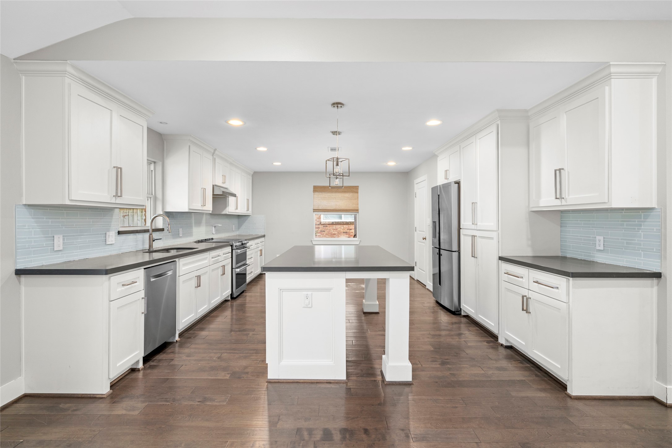 5723 Spellman Road Houston, TX 77096 - Photo 8 of 29 The renovated kitchen has quartz countertops, custom 42-inch cabinetry, stainless steel appliances, recessed lighting, and a center island with seating.