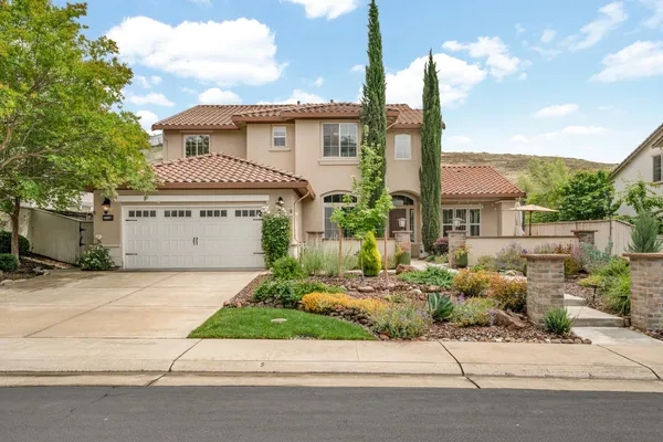 a front view of a house with a garden and parking