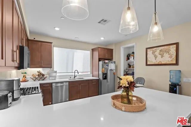 a kitchen with stainless steel appliances granite countertop a sink refrigerator and cabinets