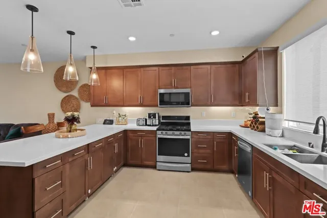 a kitchen with a sink a stove and wooden cabinets