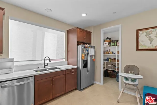 a kitchen with stainless steel appliances granite countertop a sink refrigerator and cabinets
