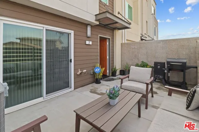 a view of a patio with a table and chairs and potted plants
