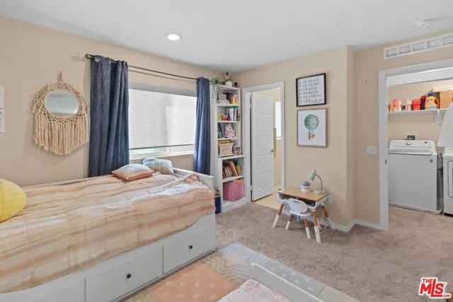 a bedroom with a bed and dresser with mirror