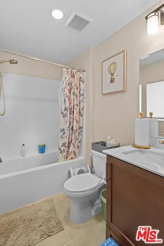 a bathroom with a granite countertop sink toilet a mirror and shower