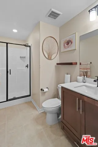 a bathroom with a granite countertop toilet sink and mirror