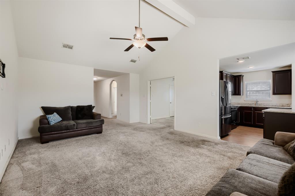 4309 Cat Tail Way Forney, TX 75126 - Photo 8 of 30 Spacious living area featuring vaulted ceilings with exposed beams, a ceiling fan, and grey carpeting