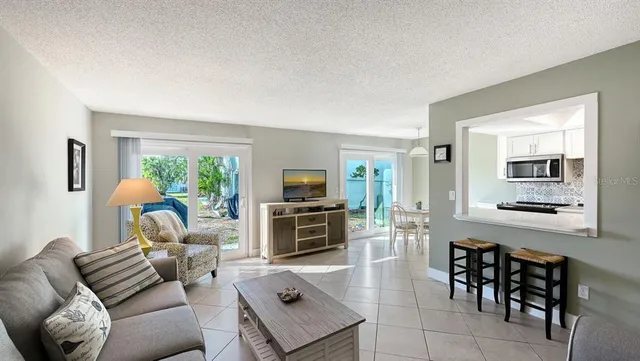 a living room with furniture a flat screen tv and a window