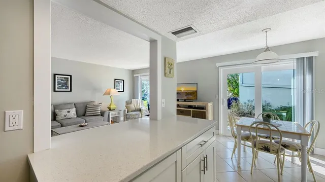a kitchen with stainless steel appliances a table and chairs in it