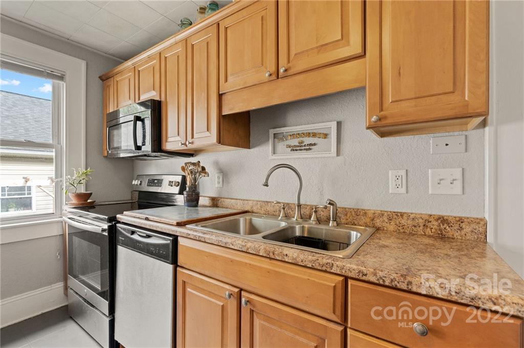 136 Round Top Road Asheville, NC 28803 - Photo 18 of 34 a kitchen with stainless steel appliances granite countertop a sink and cabinets