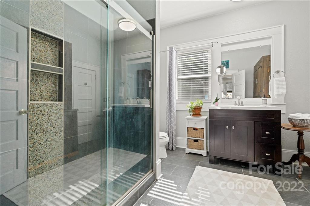 136 Round Top Road Asheville, NC 28803 - Photo 23 of 34 a bathroom with a sink a glass door and a shower