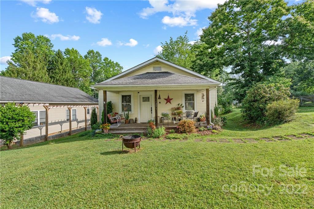 136 Round Top Road Asheville, NC 28803 - Photo 3 of 34 a front view of a house with garden and porch