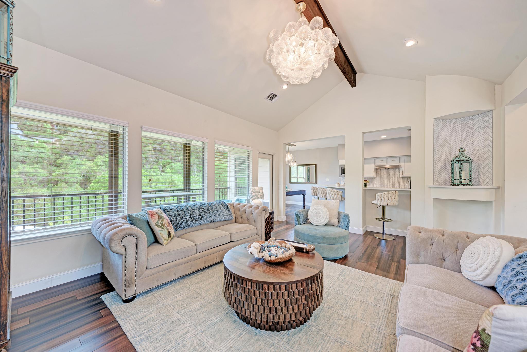 2605 Indian Creek Road Austin, TX 78734 - Photo 5 of 33 Vaulted ceilings with exposed wood beams, a modern bubble chandelier, and wood-finish flooring