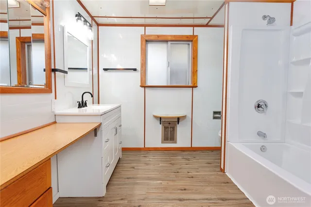 a bathroom with a tub sink and mirror