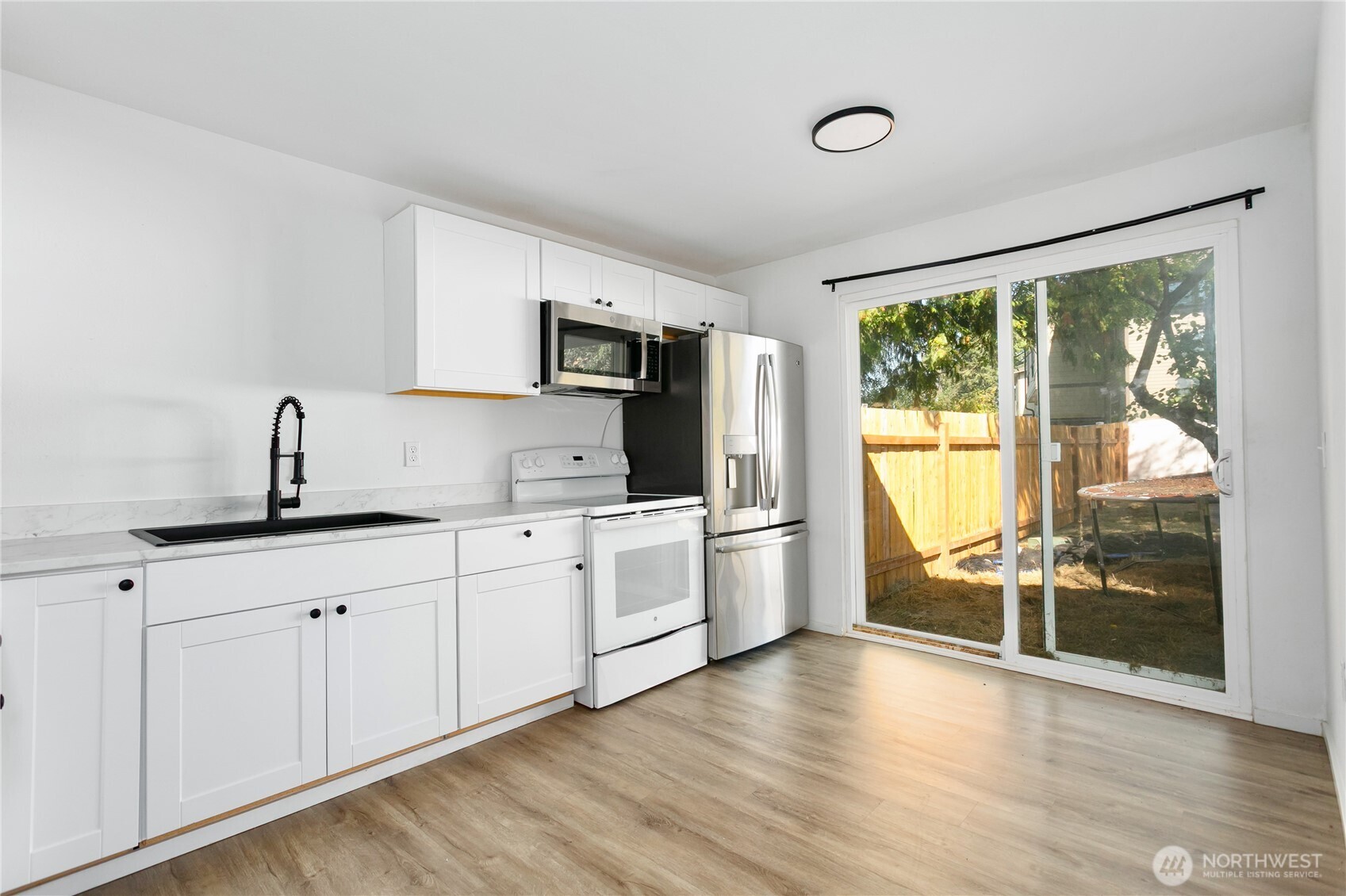 2205 South Meridian Puyallup, WA 98372 - Photo 32 of 39 a kitchen with a sink appliances cabinets and wooden floor