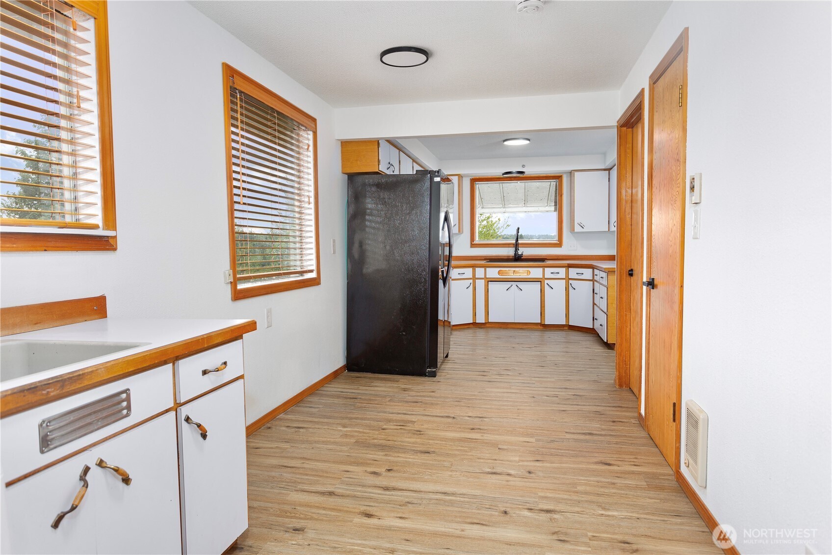 2205 South Meridian Puyallup, WA 98372 - Photo 6 of 39 a large kitchen with granite countertop a refrigerator a sink and dishwasher with wooden floor