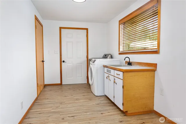 a utility room with wooden floor washer and dryer