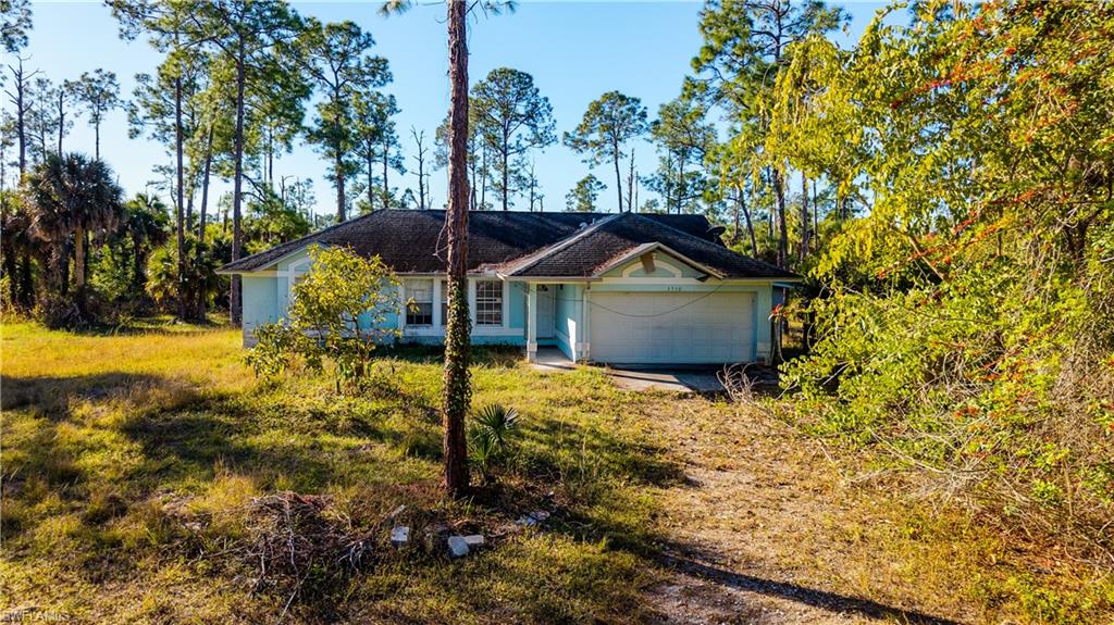 3330 12th Avenue Southeast Naples, FL 34117 - Photo 3 of 9 a front view of a house with a yard