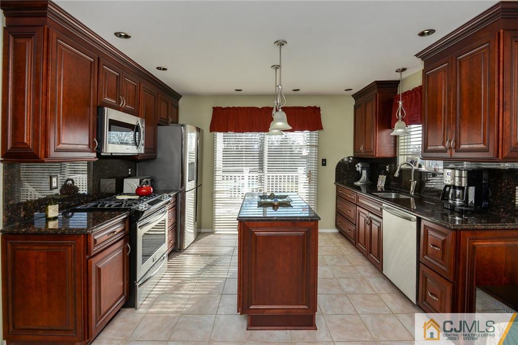 135 Disbrow Road Old Bridge, NJ 07747 - Photo 18 of 25 a kitchen with granite countertop a stove sink and cabinets