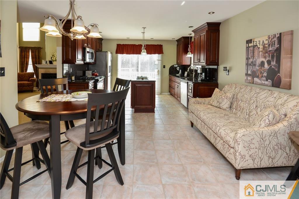 135 Disbrow Road Old Bridge, NJ 07747 - Photo 19 of 25 a kitchen with stainless steel appliances kitchen island granite countertop a refrigerator a stove a sink a dining table and chairs with wooden floor
