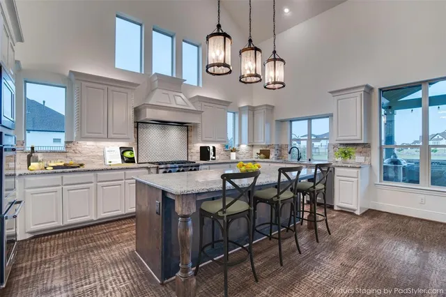 a kitchen with cabinets a counter and chairs in it