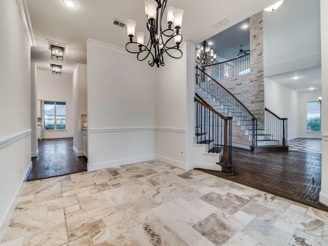 a view of a hallway with wooden floor and staircase