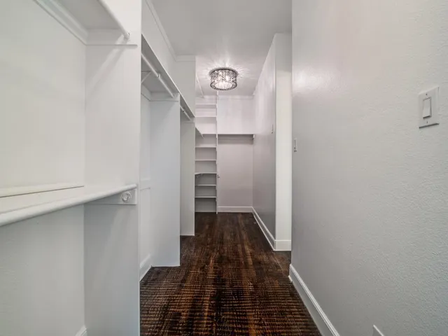 a view of a hallway with wooden floor and entryway