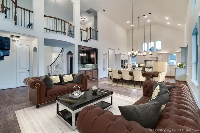 a living room with furniture kitchen view and a chandelier