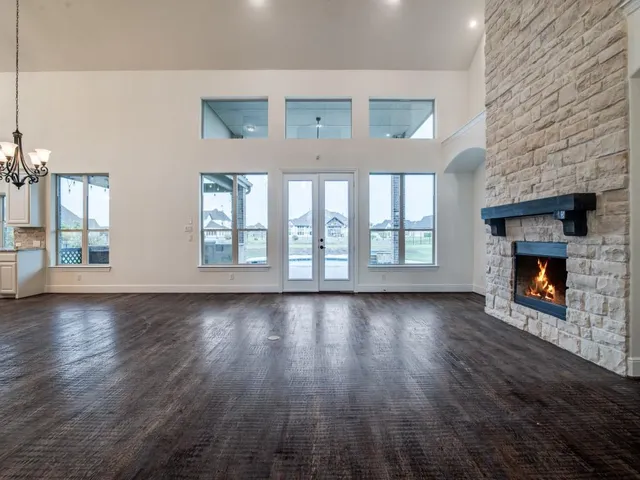 a view of an empty room with wooden floor and a fireplace