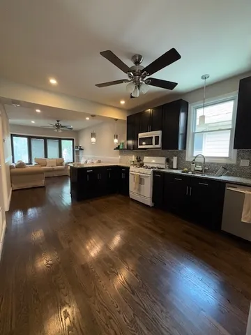 a large kitchen with stainless steel appliances granite countertop a stove and a sink