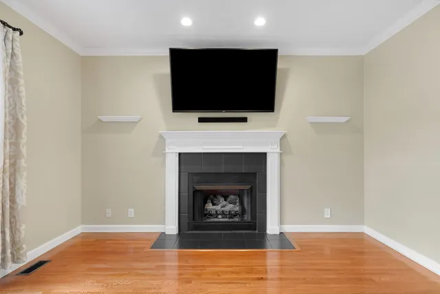 a view of a livingroom with a flat screen tv wooden floor and a ceiling fan