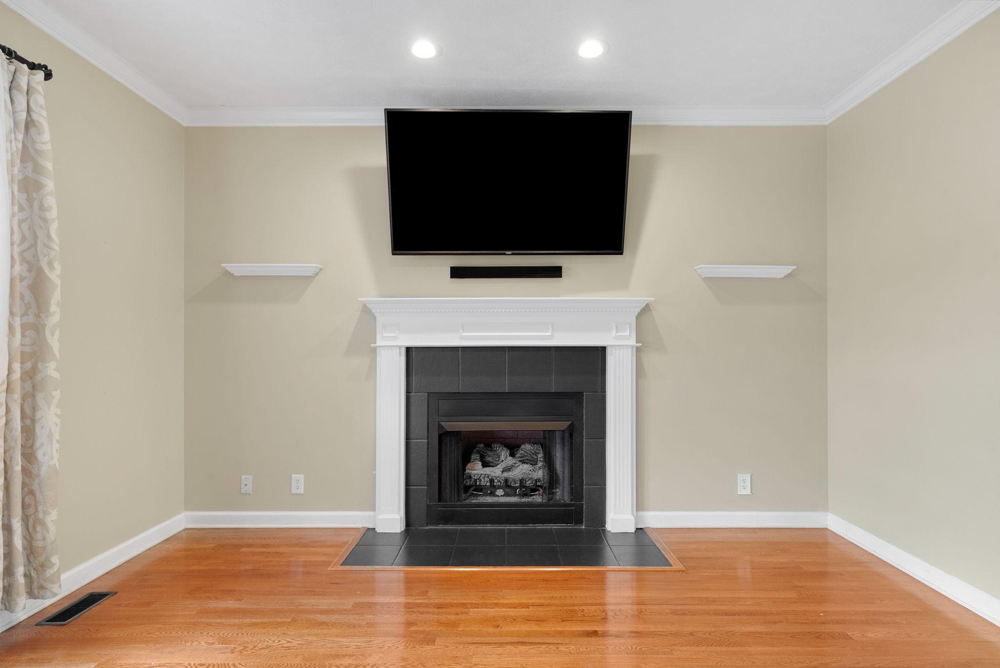 1026 Bluejay Lane Adams, TN 37010 - Photo 15 of 56 a living room with a fireplace a flat screen tv and a ceiling fan