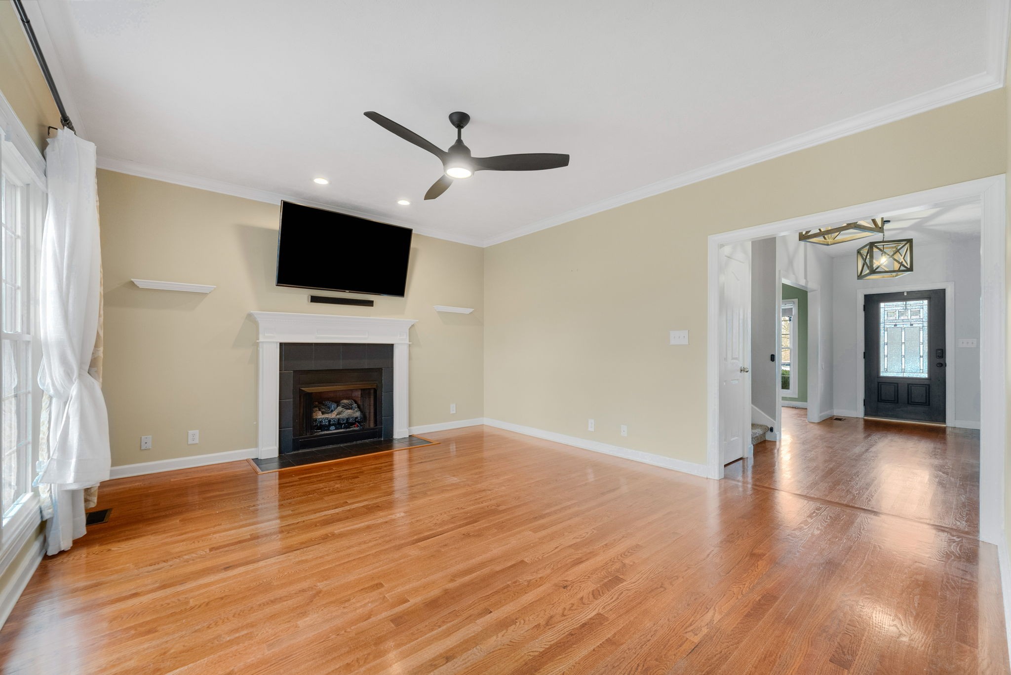 1026 Bluejay Lane Adams, TN 37010 - Photo 16 of 56 a view of a livingroom with a flat screen tv wooden floor and a ceiling fan