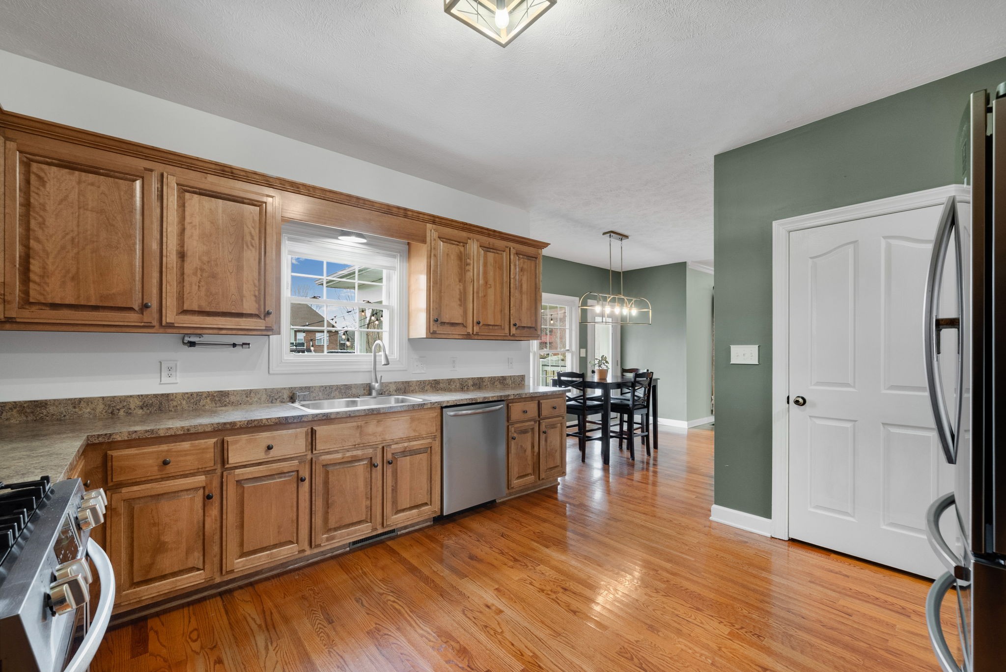 1026 Bluejay Lane Adams, TN 37010 - Photo 23 of 56 a kitchen with stainless steel appliances granite countertop wooden cabinets a dining table and chairs