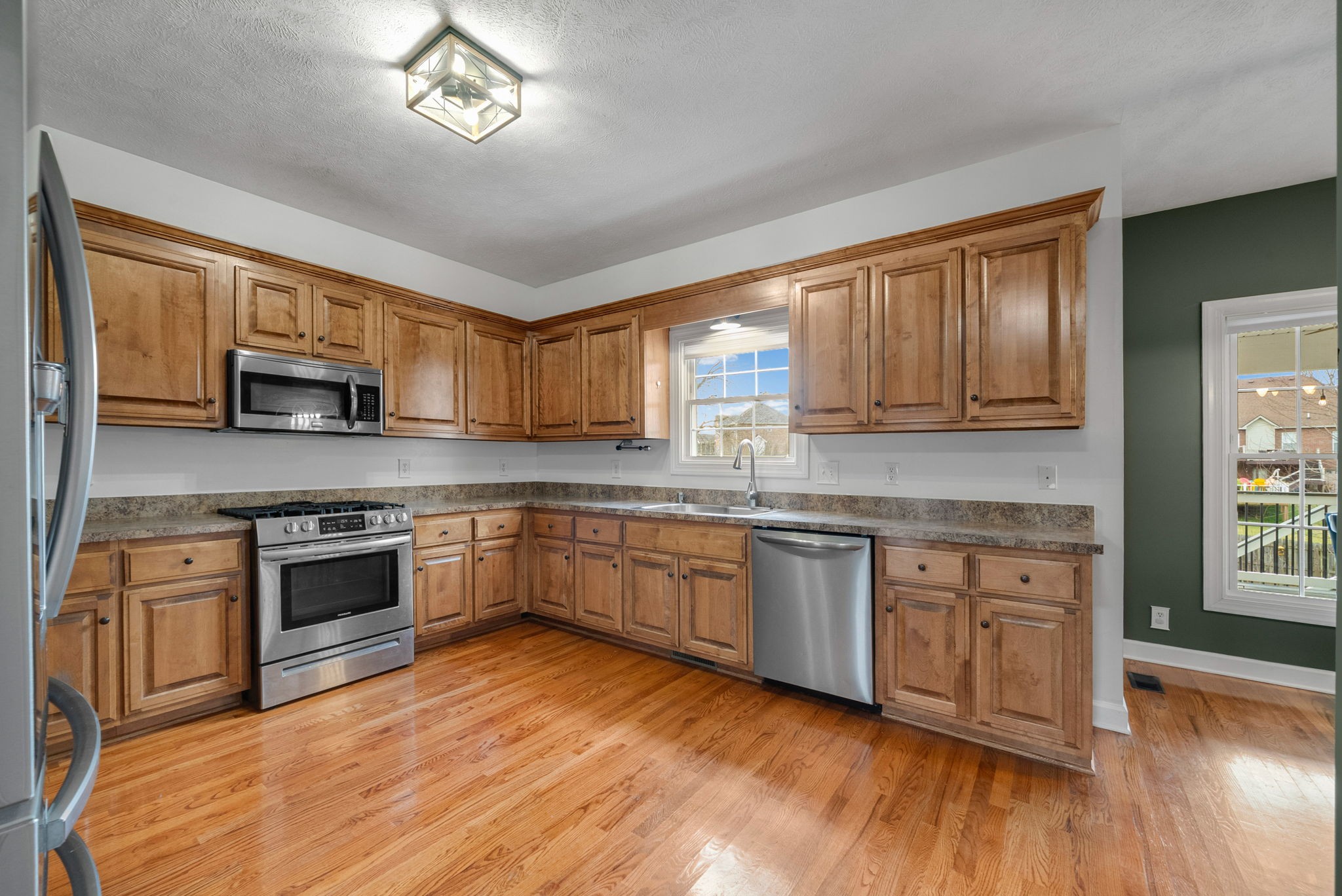 1026 Bluejay Lane Adams, TN 37010 - Photo 24 of 56 a kitchen with stainless steel appliances granite countertop wooden cabinets a sink a stove a dining table and chairs