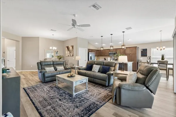 a living room with furniture wooden floor and a chandelier