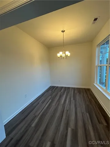 a view of wooden floor chandelier and window in a room