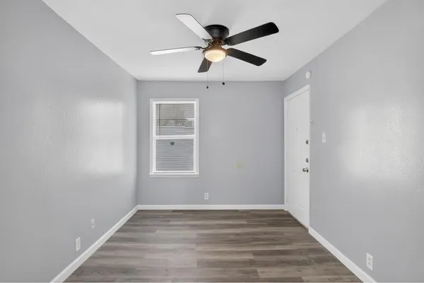 a view of empty room with wooden floor