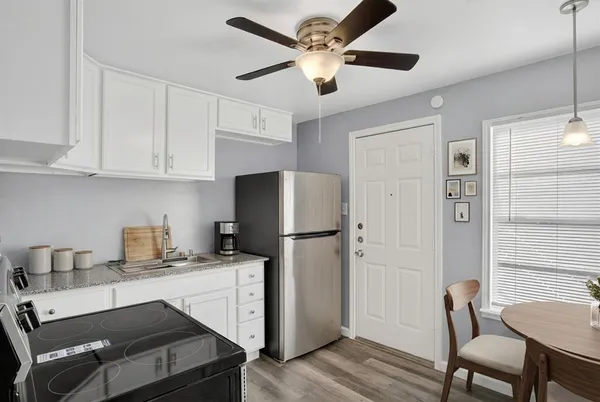 a kitchen with stainless steel appliances white cabinets and a refrigerator
