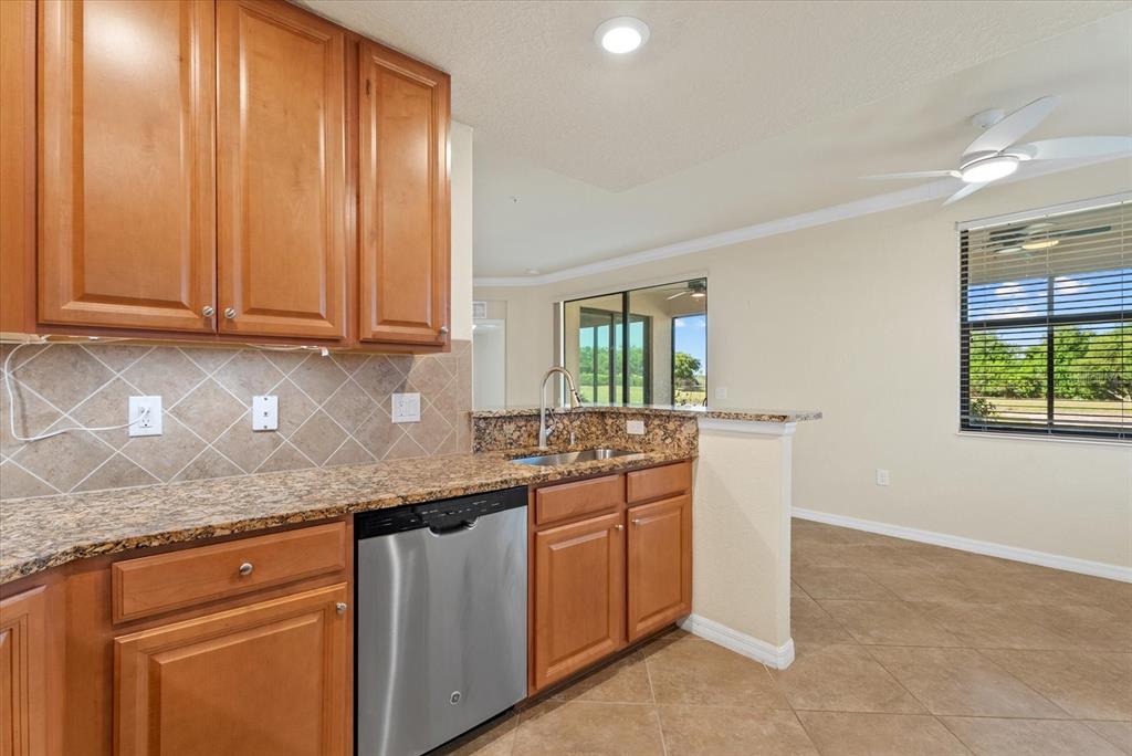 20080 Ragazza Circle, Unit 102 Venice, FL 34293 - Photo 21 of 49 a kitchen with stainless steel appliances granite countertop a sink and cabinets with wooden floor