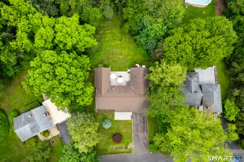 an aerial view of a house with a yard and large trees