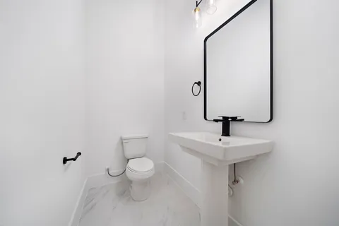 a bathroom with a toilet sink and mirror