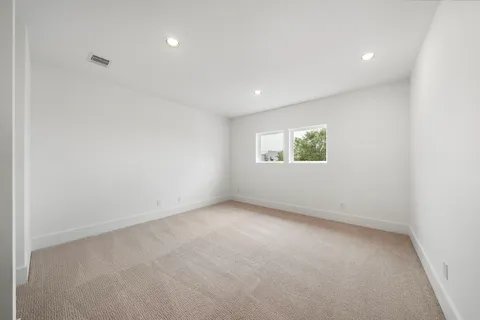 an empty room with white cabinet and windows