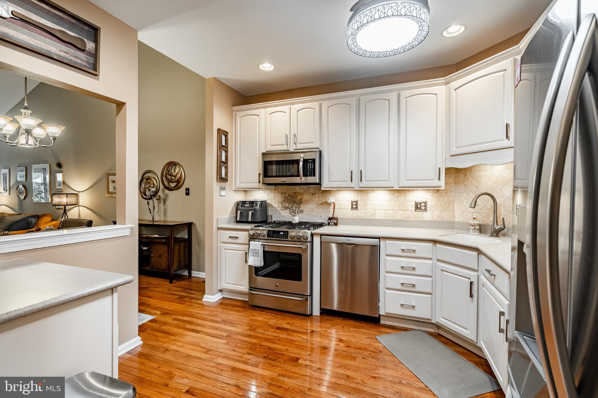 71 Dresner Circle Upper Chichester, PA 19061 - Photo 6 of 46 a kitchen with stainless steel appliances granite countertop a stove top oven a sink dishwasher and a refrigerator with wooden floor