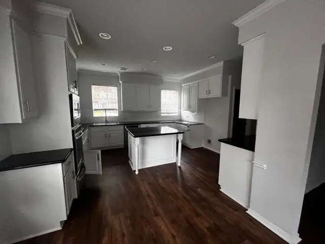 a kitchen with a refrigerator and a stove top oven