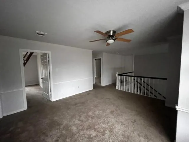 a view of a livingroom with a ceiling fan and window